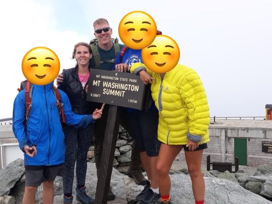 A group of people pose at Mt. Washington summit